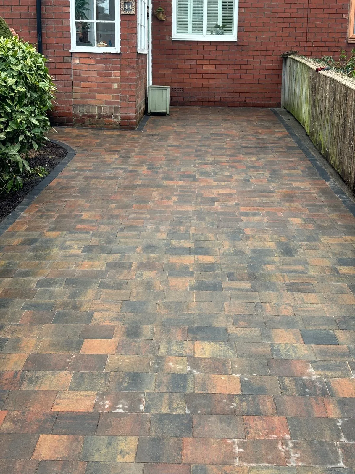 Block-paved driveway beside a brick home