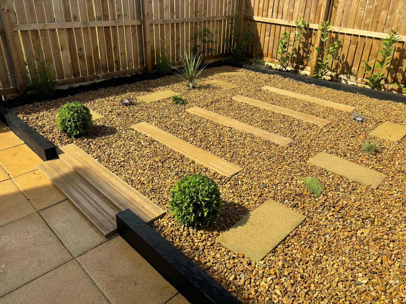 Gravel garden with timber sleeper paths and planting